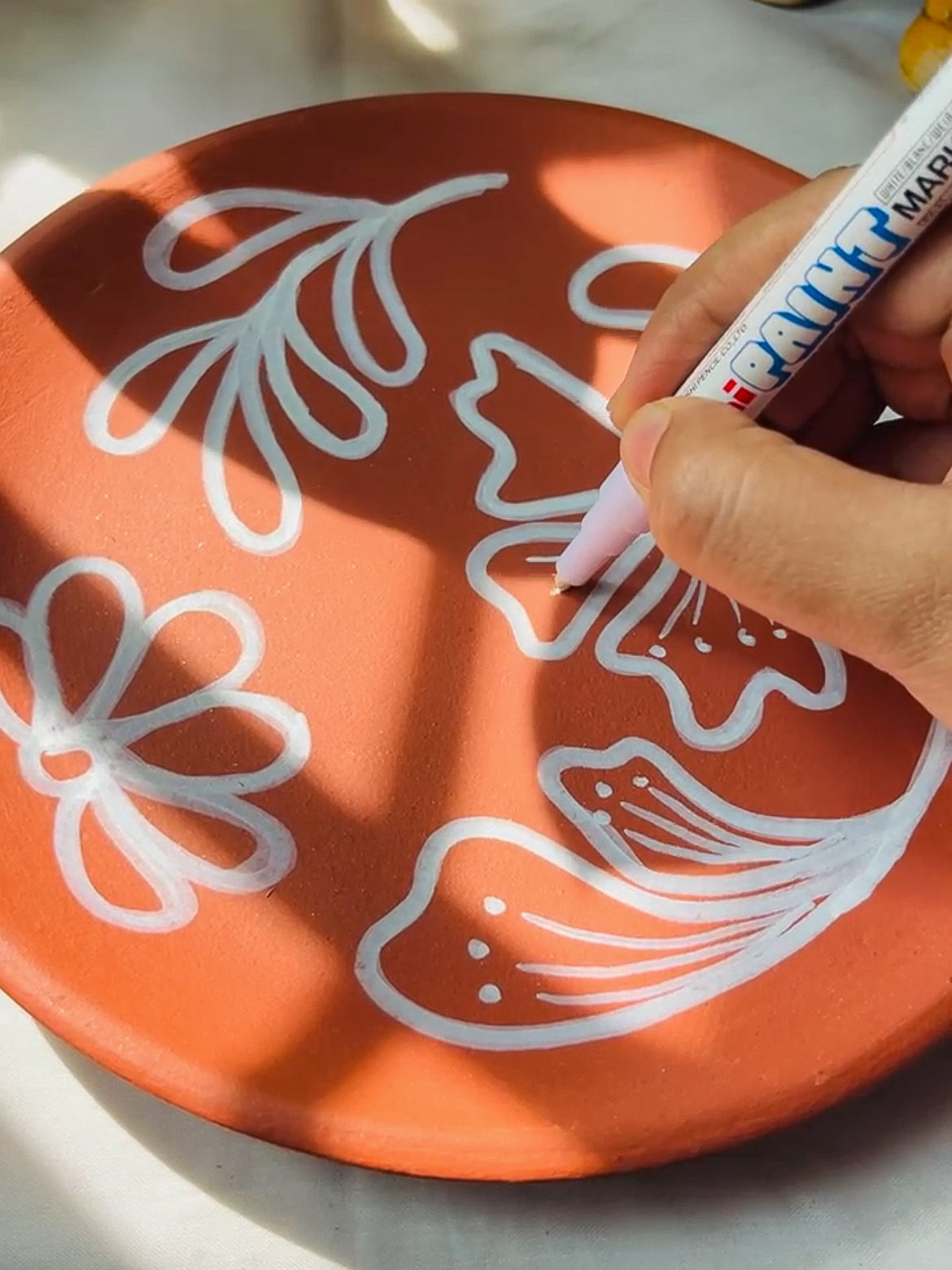 Easy painting using acrylic marker on plain terracotta wall plate