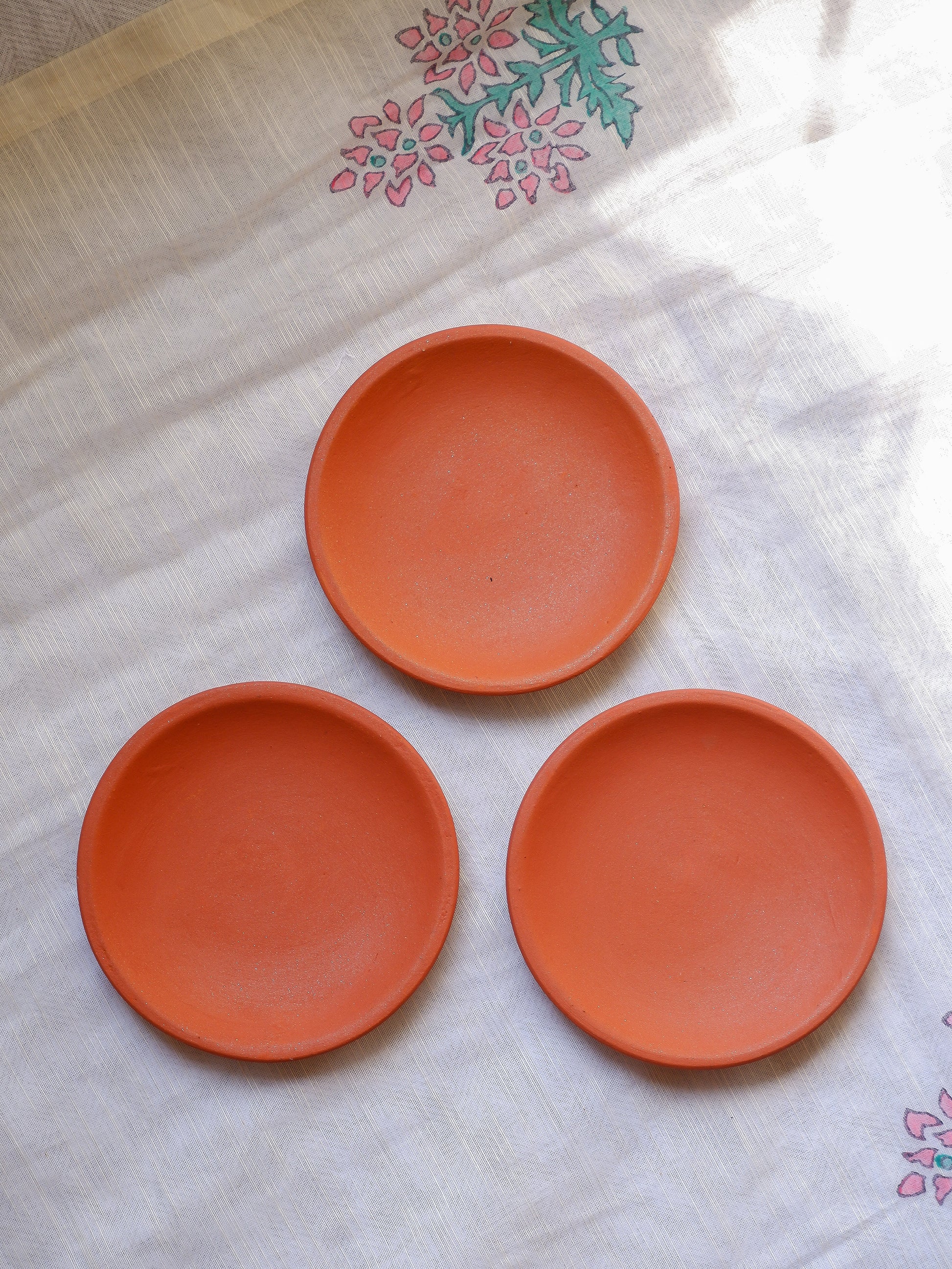 Close-up of blank terracotta wall plate showing smooth clay surface ideal for mandala or dot art.