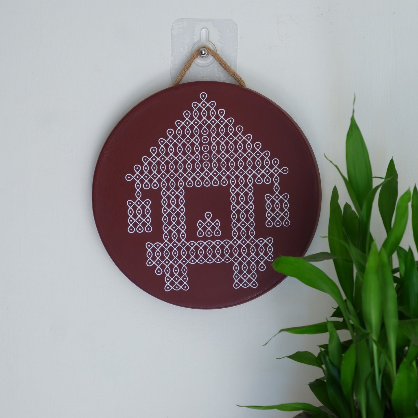Wall decor image of our 8 inch Maroon Ther Traditional South Indian Sikku Kolam Terracotta Wall Plates for Indian Homes