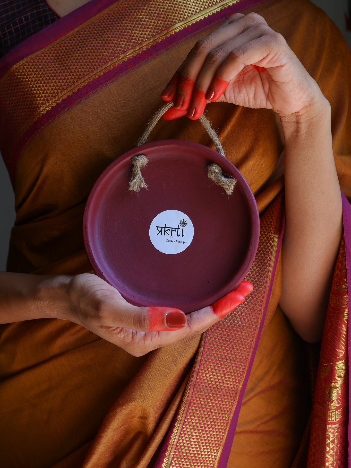 Back view of our 6 inch Maroon Traditional South Indian Sikku Kolam Terracotta Wall Plates for Indian Homes