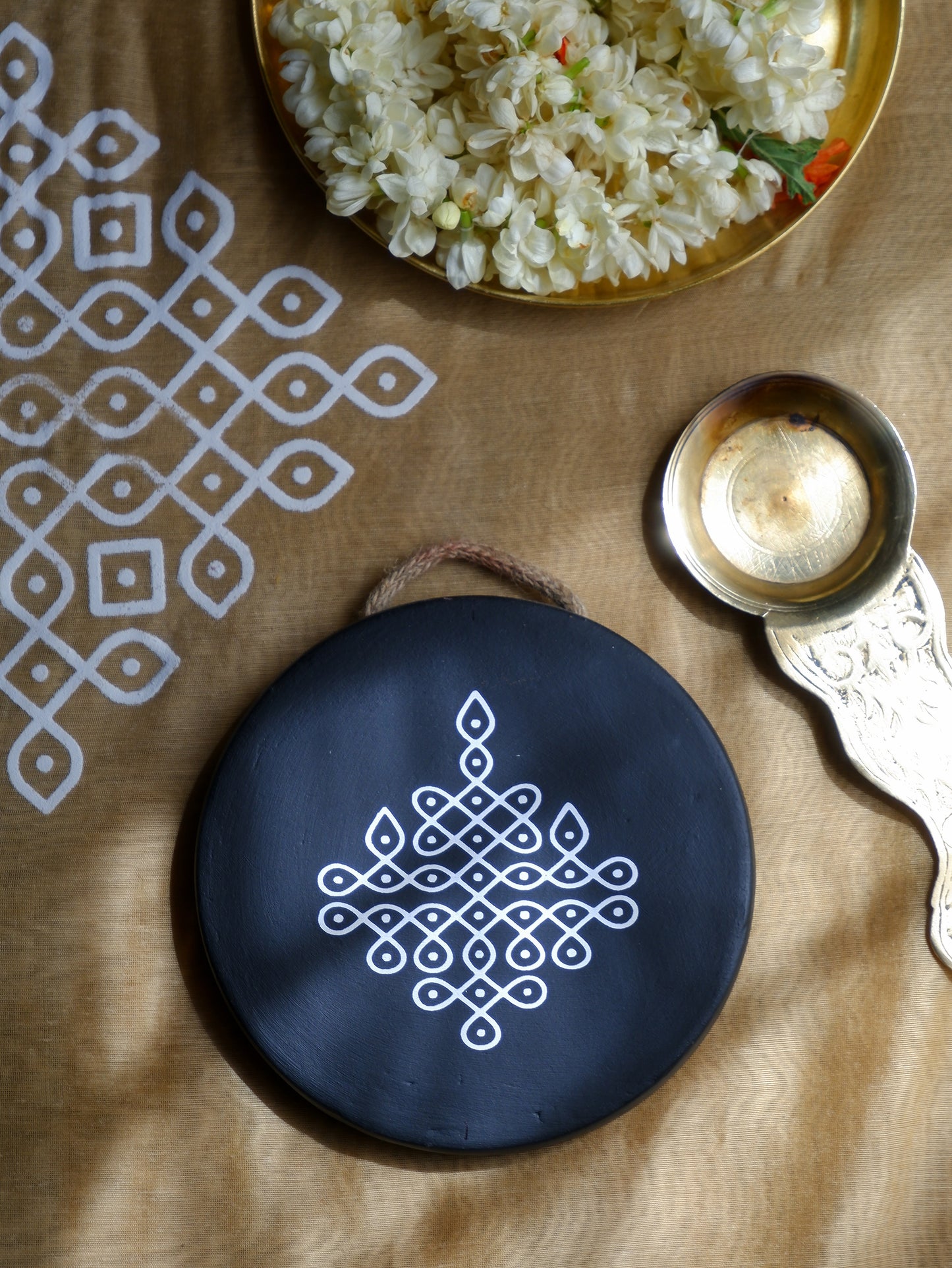 flat lay of our 6 inch black Traditional South Indian Sikku Kolam Terracotta Wall Plates