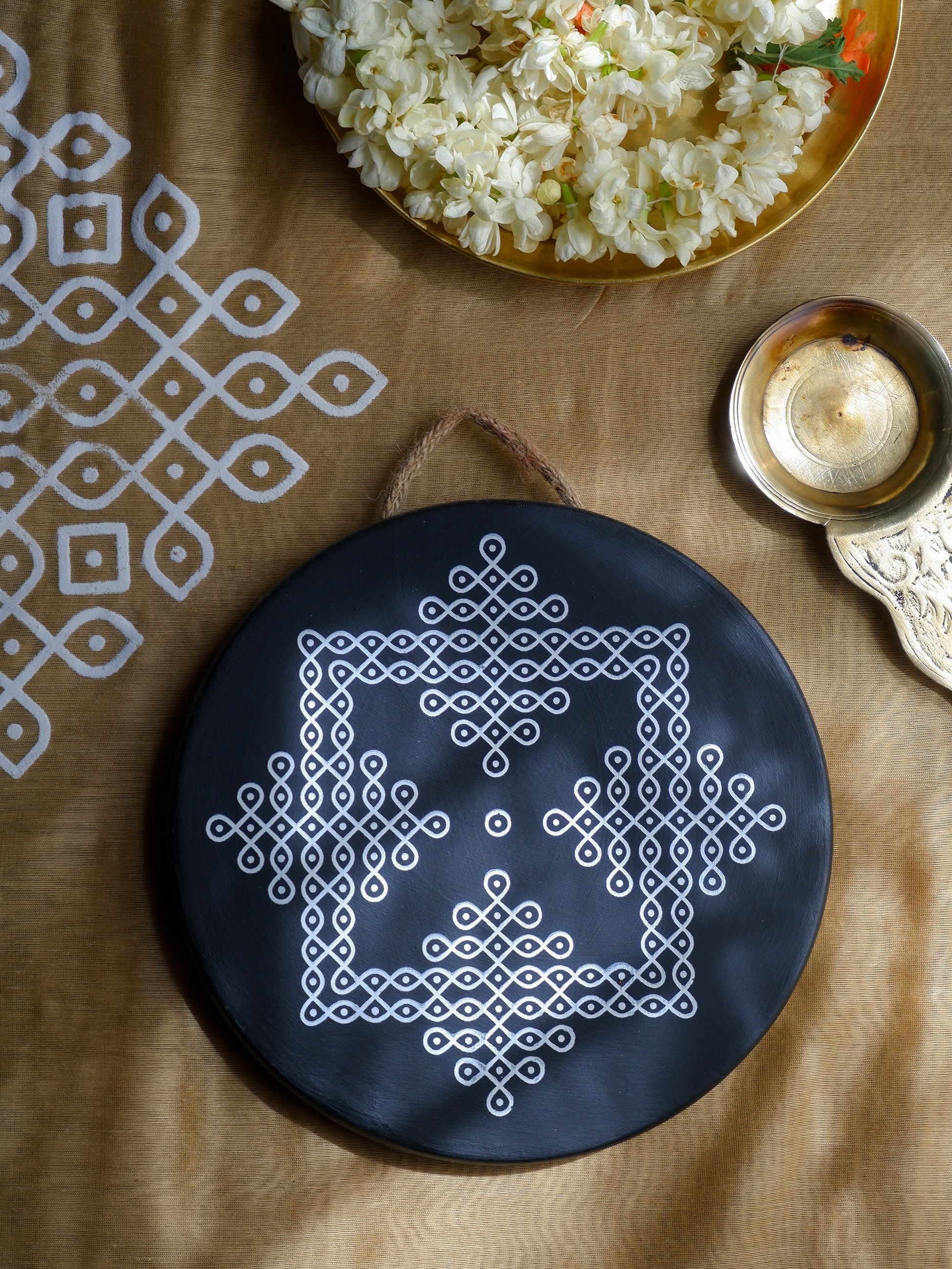 flat lay image of 8 inch  black Traditional South Indian Sikku Kolam Terracotta Wall Plates for Indian Homes