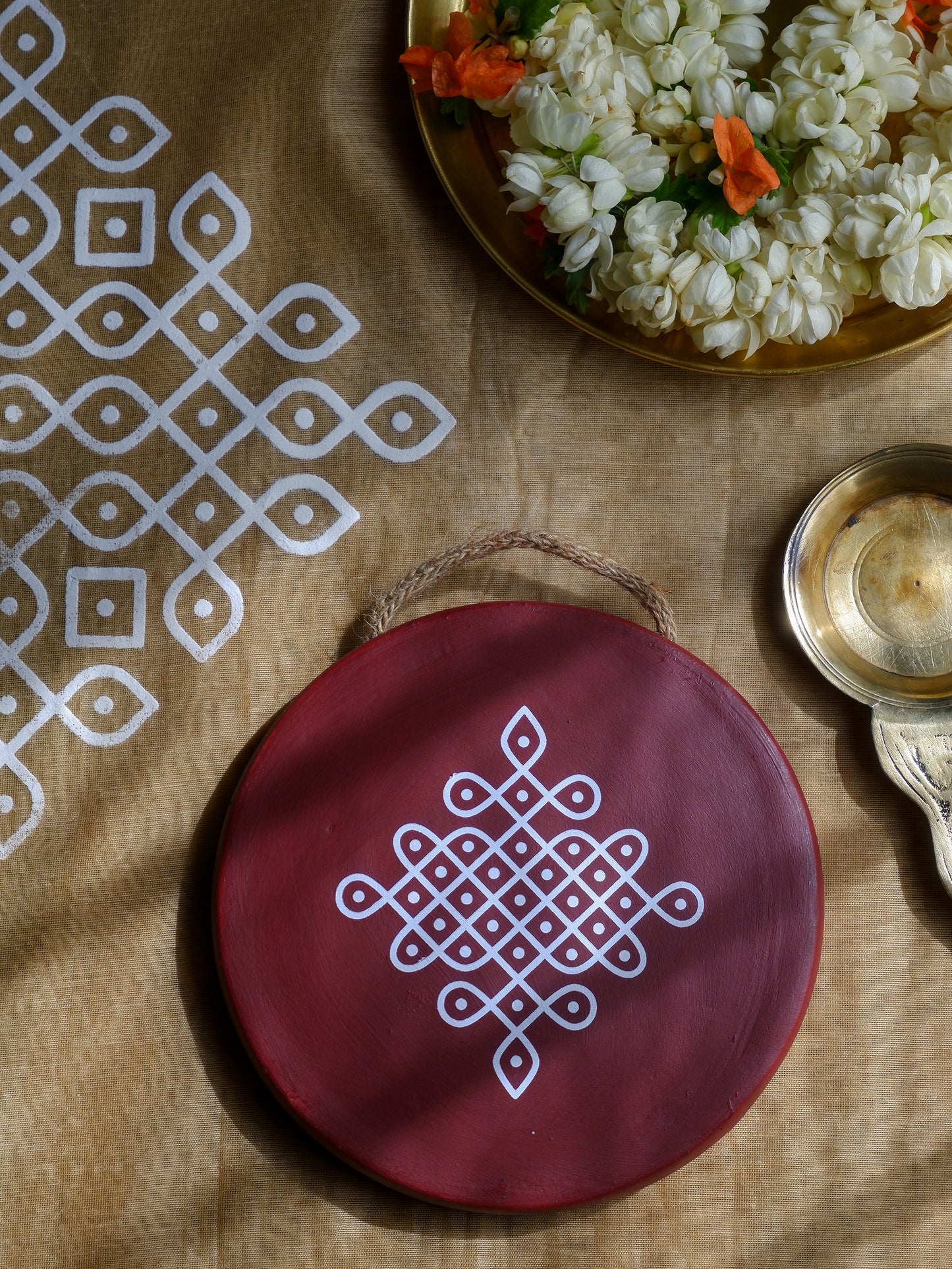 flat lay image of 6 inch Maroon Traditional South Indian Sikku Kolam Terracotta Wall Plates