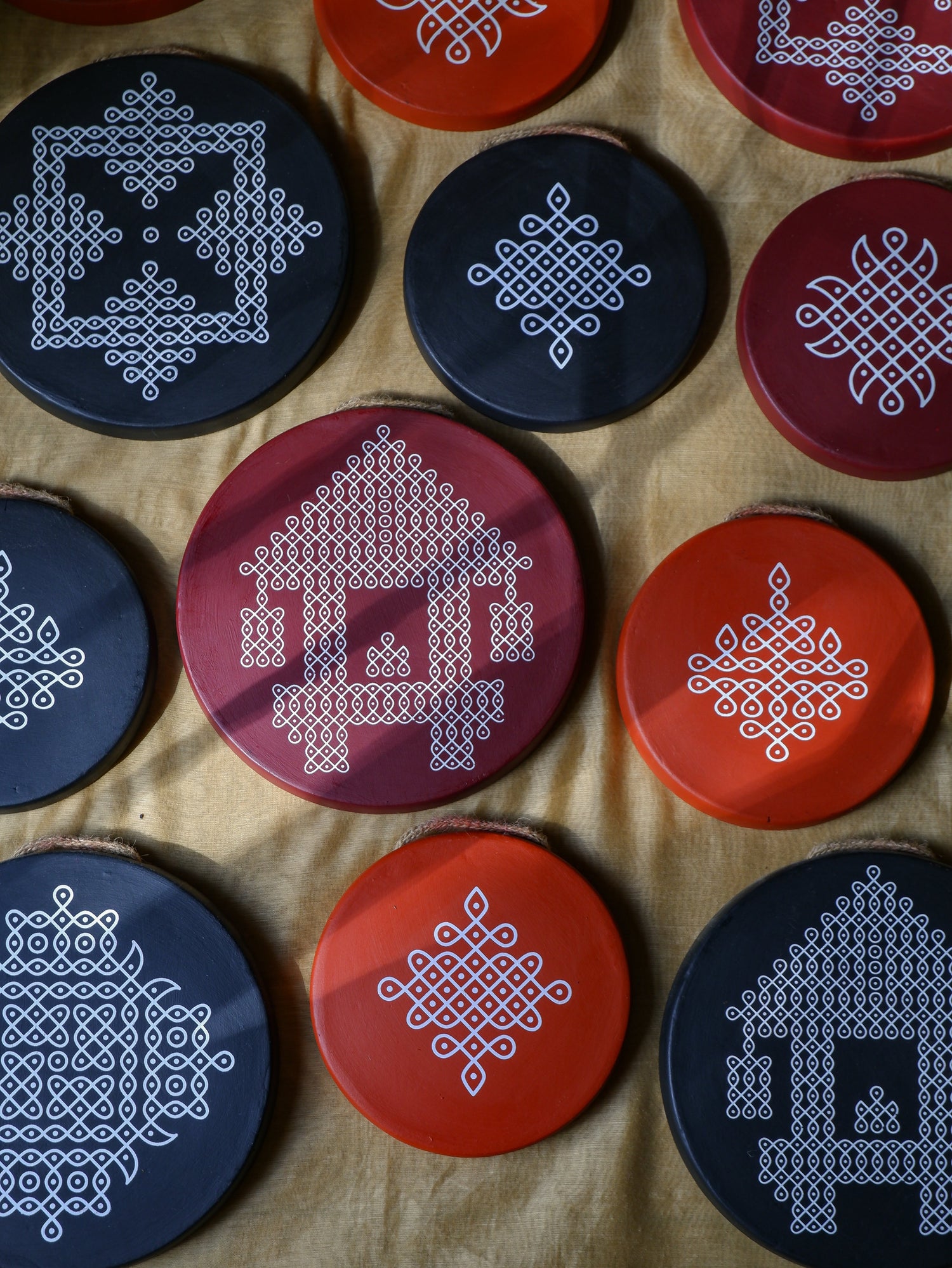 Assortment of traditional Sikku Kolam Terracotta Wall plates for wall hanging in size 6 inch and 8 inch in colors black maroon.