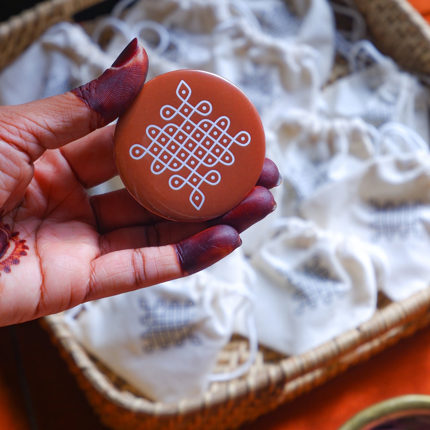 Orange Fridge Magnet featuring intricate Kolam artwork